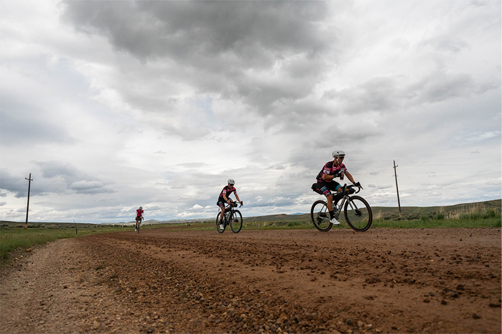 people biking on dirt road